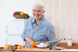 Elderly lady cutting an orange Elderly lady cutting an orange