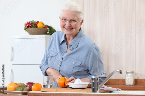 Photo: Elderly lady cutting an orange Elderly lady cutting an orange