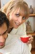 Woman drinking coffee next to husband