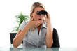 Office worker looking through a pair of binoculars