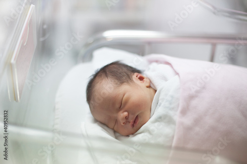 Photo: new born infant asleep in the blanket in delivery room new born infant asleep in the blanket in delivery room