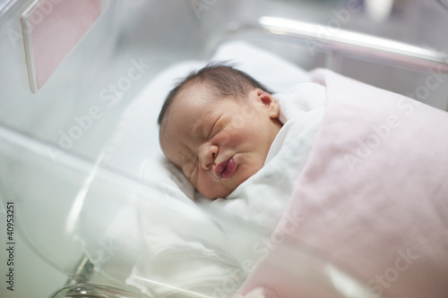 Photo: new born infant asleep in the blanket in delivery room new born infant asleep in the blanket in delivery room