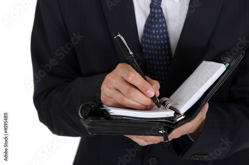 Foto: Man writing in his business diary Man writing in his business diary