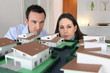Couple looking at a model of a housing estate Couple looking at a model of a housing estate