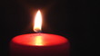 Single red candle burning