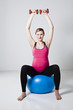 Pregnant woman exercising with dumbbells