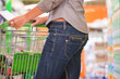 Junge Frau schiebt Einkaufswagen in Supermarkt