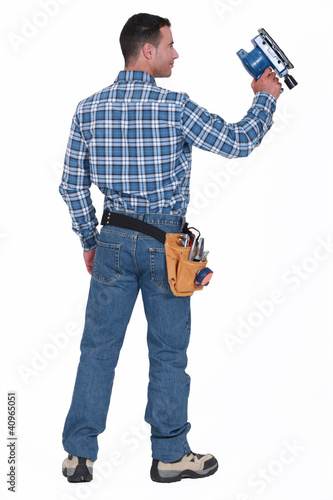 Photo: Rear view of a man with a sander Rear view of a man with a sander