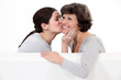 Daughter giving her mother a kiss on the cheek
