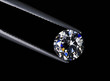 diamond in the tweezers on a black background