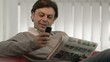 Happy businessman reading real estate ads on newspaper