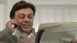 Happy businessman reading stock exchange listings on newspaper