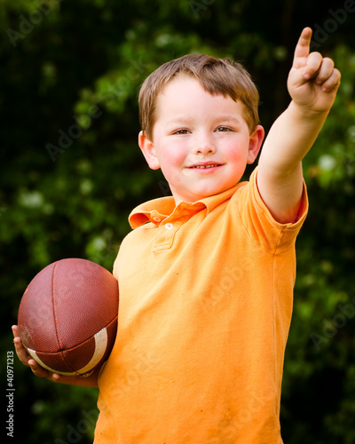Photo: Child with football celebrating by showing that he's Number 1 Child with football celebrating by showing that he's Number 1