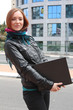 Young woman with her laptop, at the street