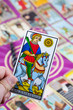 Cavalier de Deniers, Tarot card held in the hand Cavalier de Deniers, Tarot card held in the hand