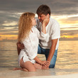 Young couple on the sea sunset background Young couple on the sea sunset background