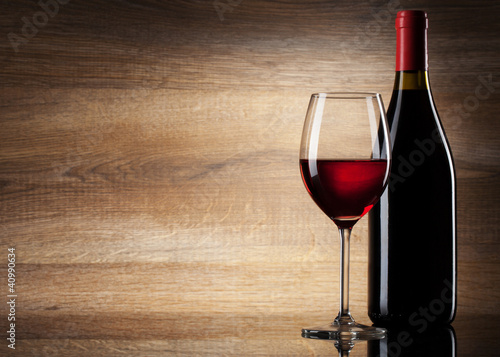 Photo: Wine glass and Bottle on a wooden background Wine glass and Bottle on a wooden background