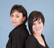 Sisters standing back against each other