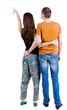 Back view of young couple pointing at wall