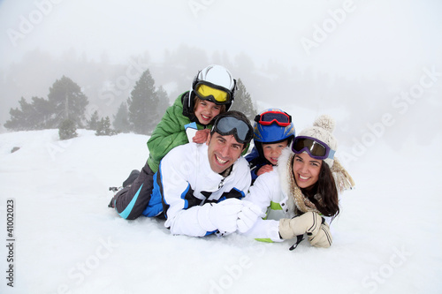 Photo: Happy family laying down in the snow Happy family laying down in the snow