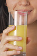 Joven mujer bebiendo jugo de naranja.