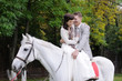 Happy bride and groom on a horse