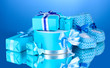 beautiful gifts and baby's bootees on blue background