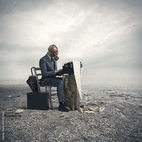 Photo: business wearing a gas mask, write with an old typewriter business wearing a gas mask, write with an old typewriter