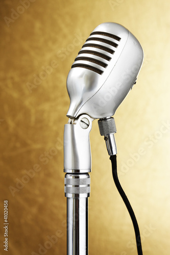 Photo: Retro style microphone. Gold background Retro style microphone. Gold background
