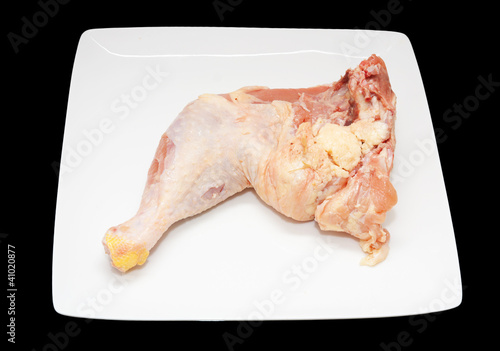 Foto: fresh chicken whole leg in a white plate on a black background fresh chicken whole leg in a white plate on a black background