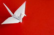 A white paper bird on a red background