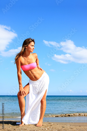 Foto: Young woman standing on a beach Young woman standing on a beach
