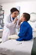 Foto: Pediatrician examining child’s throat with tongue depressor Pediatrician examining child’s throat with tongue depressor