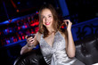 Young woman in night club with a drink
