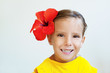 little girl in yellow dress with red flower