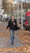 Pretty woman walking on the street, at autumn