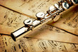 Silver flute on an ancient musical background
