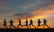 Marathon, black silhouettes of runners on the sunset