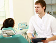 Young woman with dentist in a dental surgery.
