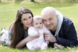 family of three in park with baby