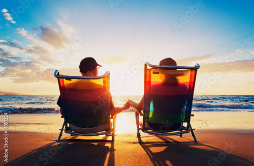 Photo: senior couple of old man and woman sitting on the beach watching senior couple of old man and woman sitting on the beach watching