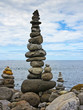 high stack of pebbles on the beach and sea background high stack of pebbles on the beach and sea background