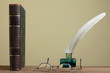 Antique book, spects, quill and inkwell on wooden table