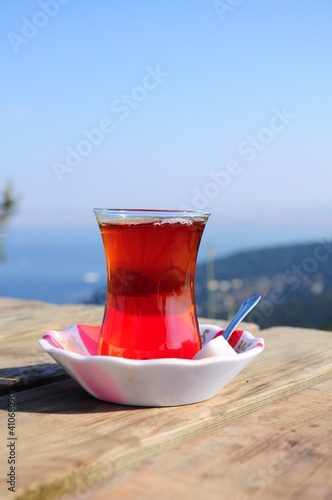 Photo: a glass of black (red) tea on table a glass of black (red) tea on table