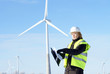 engineer or architect with white safety hat and wind turbines on engineer or architect with white safety hat and wind turbines on