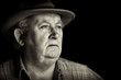 senior male retired wearing a hat on black