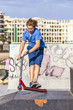 boy rides his scooter at the skate park boy rides his scooter at the skate park