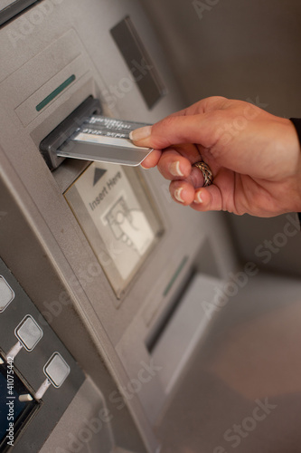 Photo: Female hand inserting ATM card Female hand inserting ATM card
