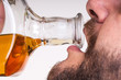 Drunk man drinking from a bottle of whisky Drunk man drinking from a bottle of whisky