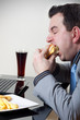 Businessman eating junk food while working